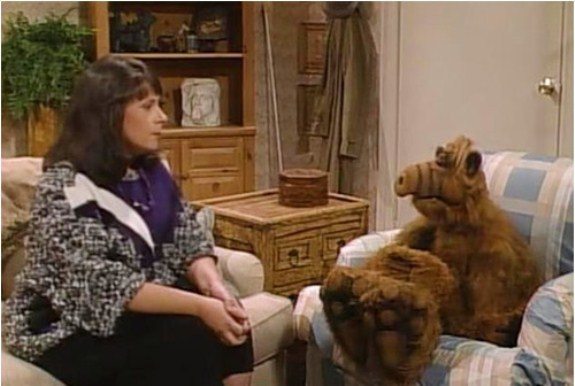 Jody sitting on a couch across from ALF