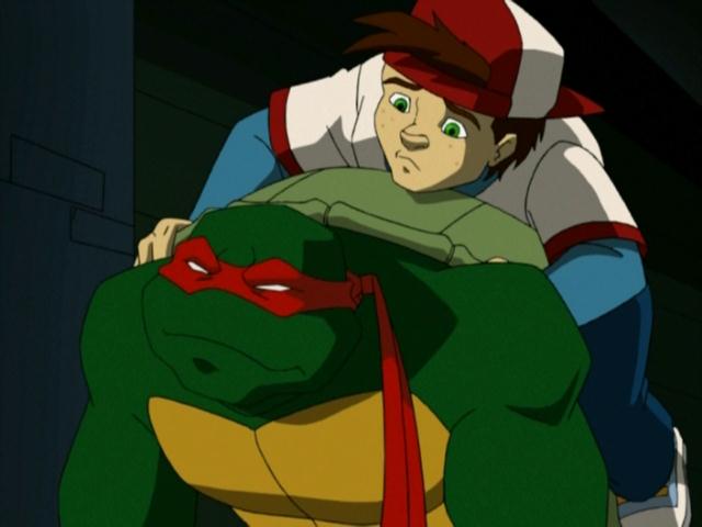 Raphael carrying a kid on his back. The boy helps to orient Raphael after he is blinded during episode of Teenage Mutant Ninja Turtles.