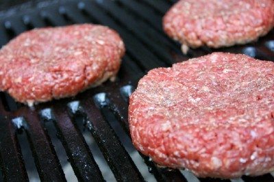 Image showing raw hamburger patties on a grill Image showing raw hamburger patties on a grill