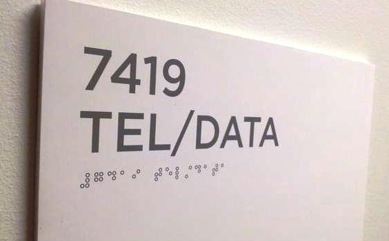Office sign with printed braille characters instead of embossed braille characters