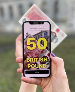 Individual using the Cash Reader app by using their smart phone camera to capture the bill. In big yellow letters, the app states that the image is a "50 British Pound." 