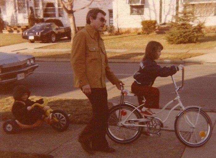 Photo showing Lou Fioritto walking alongside his daughter Christine while she's learning to ride a bike.