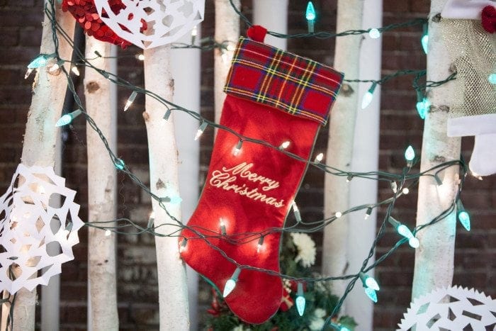 Christmas stocking, lights and paper cut-out snowflakes hanging in a tree