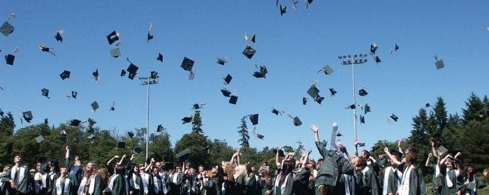 Large group of graduates tossing their caps into the air.