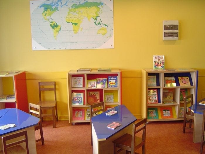 Classroom with small desks and a few bookshelves