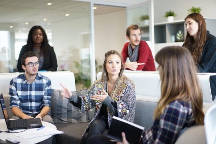 Six people in discussions during a team meeting on banking accessibility.