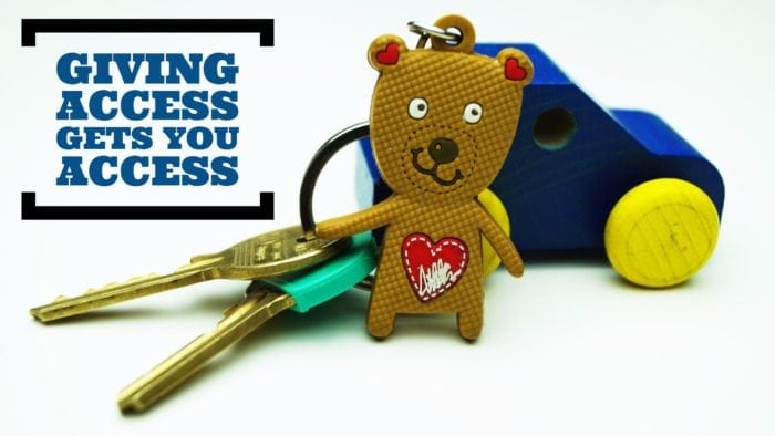 Key chain with a small plastic bear attached. The phrase "giving access gets you access" is displayed in text.