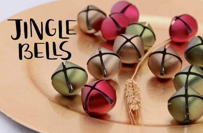 Several jingle bells on a dinner plate.