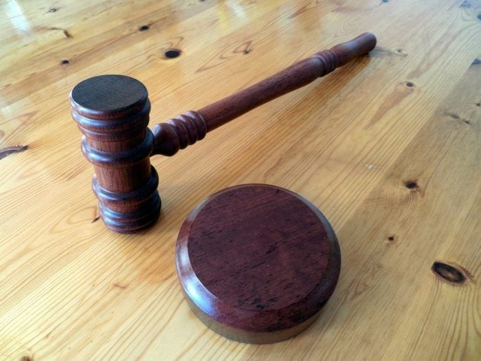 A gavel resting on a wooden table.