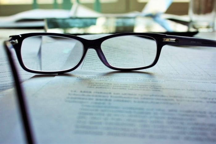 A pair of glasses resting on top of print documents.