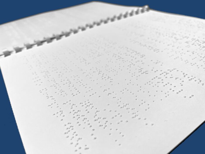 An open, comb-bound braille document