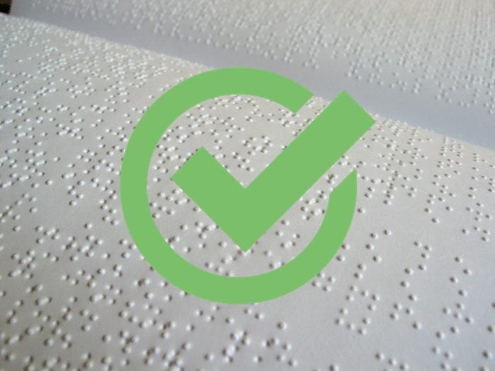 Braille with green checkmark over it