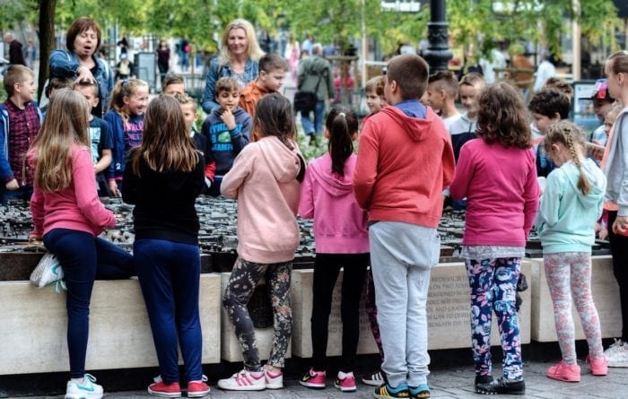 public education students besides a tactile monument