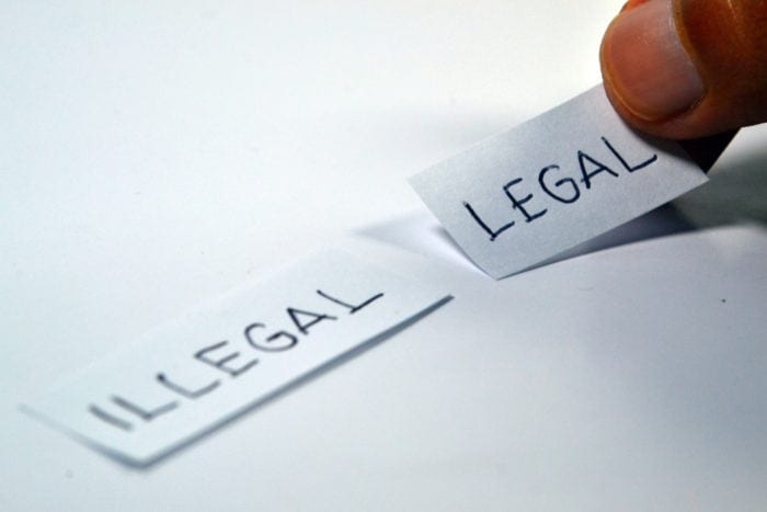 two pieces of paper with "illegal" and "legal" written