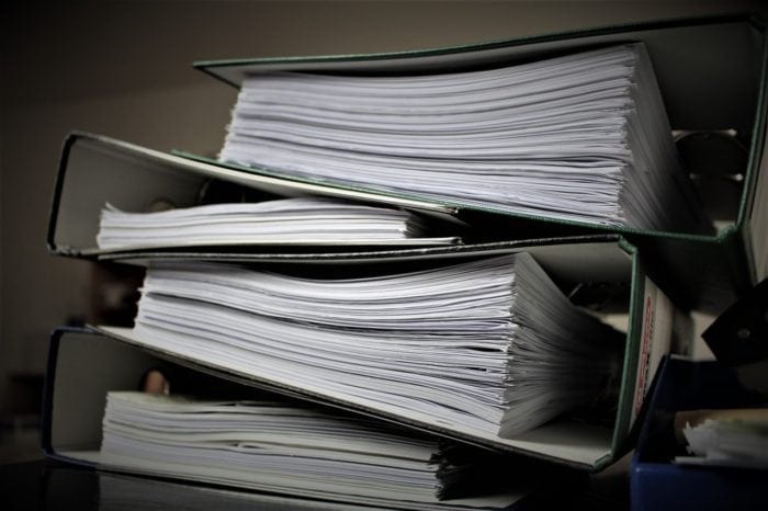 A stack of binders full of legal proceedings.