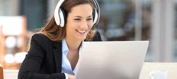 Employee wearing headphones and watching a training video.