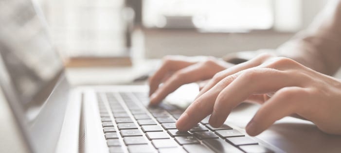 Employee typing on a laptop keyboard