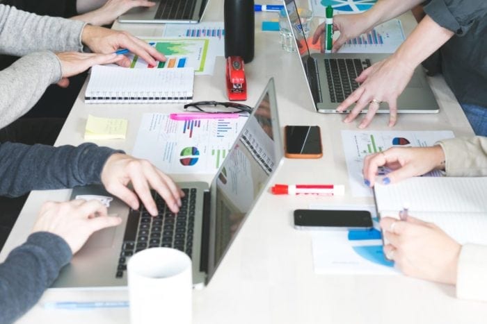 Employees of a marketing agency at a table working on a project together