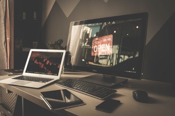 Computers, tablet and phone on a desk open to everyone because of WCAG