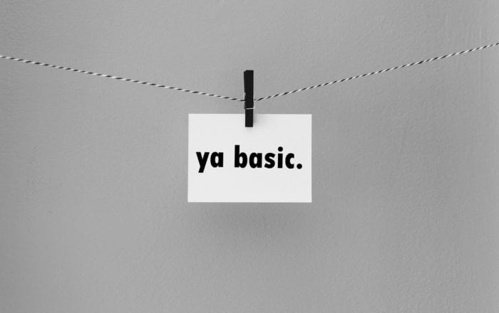 Note card with the text "ya basic." held on a string by a clothespin