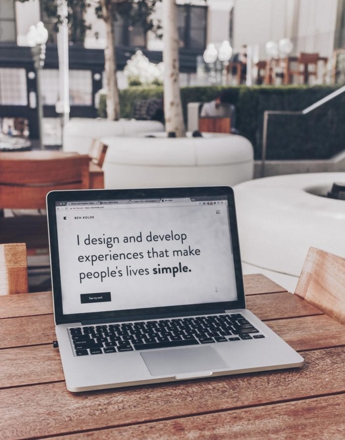 a laptop screen that reads "I design and develop experiences that make people's lives simple"