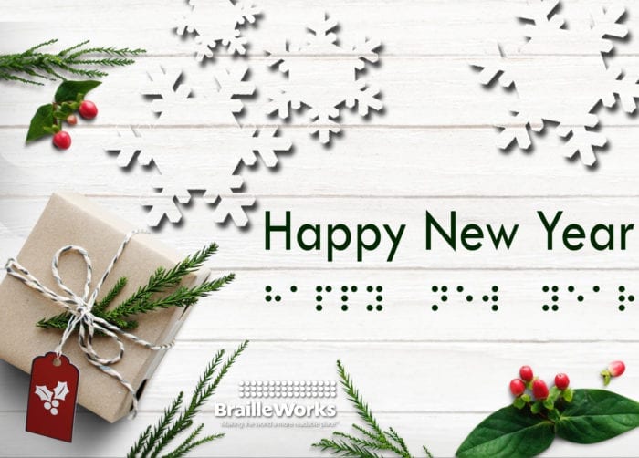 The words, "Happy New Year" in print and braille dots surrounded by Christmas greenery and a present