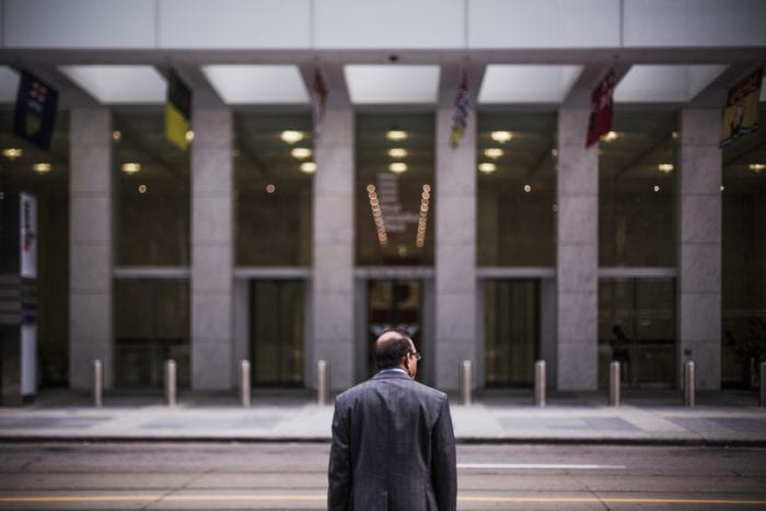 businessman staring across the street at a large bank office