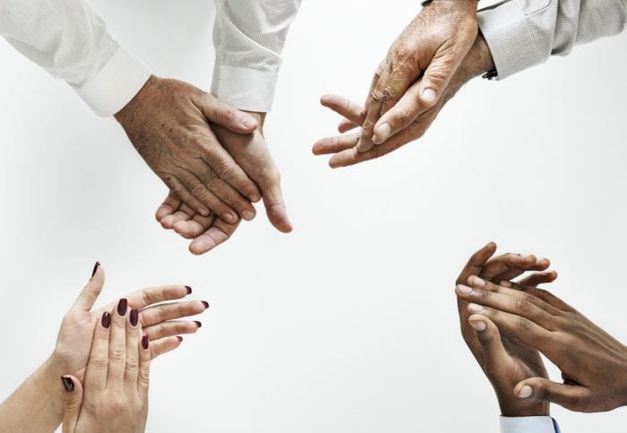 four hands clapping at the center