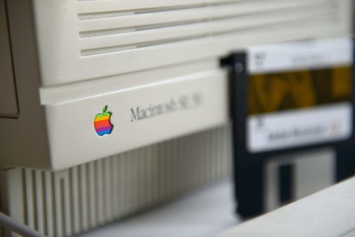 Close-up of the bottom right corner of a vintage Macintosh monitor and blurred out floppy disk