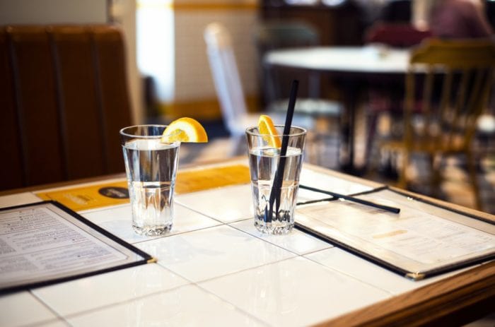 two water glasses and menus on a table