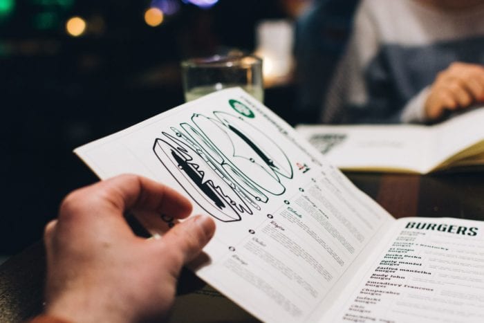 a hand holding a kids menu with a burger on it