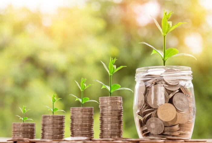 4 progressively increasing stacks of coins with plants growing out of the top and a final jar of coins with the largest plant growing out of the top showing a boost in revenue