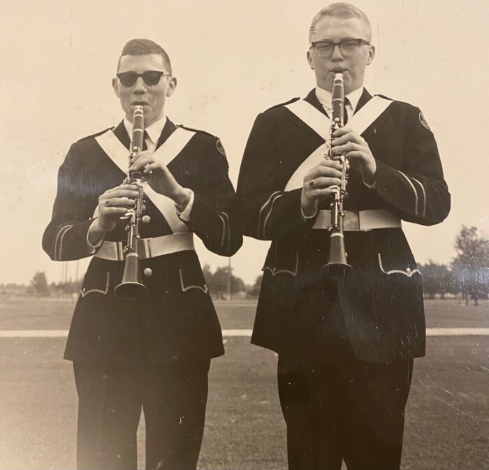 The author's father in his high school marching band uniform playing the clarinet with his bandmate.
