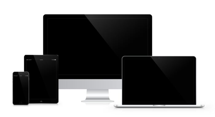 Photo of a desktop computer, laptop, tablet, and smartphone.