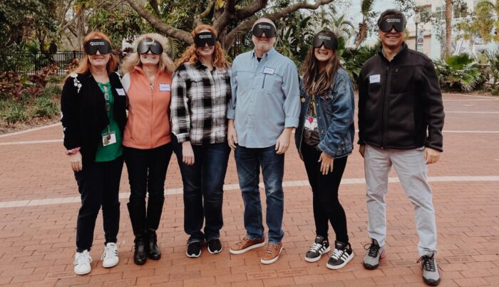 The Braille Works sales and marketing team standing together with their blindfolds on