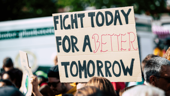 Protest with a sign reading "Fight for a better tomorrow"