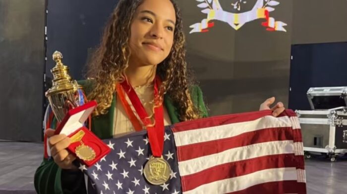 Tiffani Gay holding up her medals and the American flag