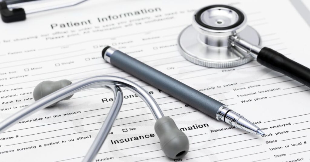 A paper Patient Information form with small print on a clipboard with a pen and stethoscope on top